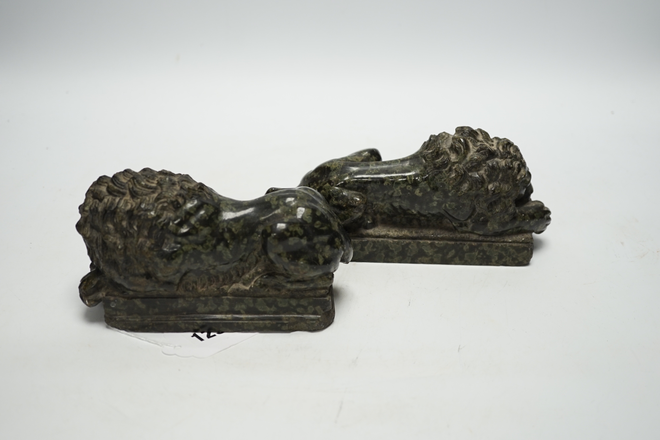 A pair of carved serpentine models of the Lucerne lions, 16cm wide